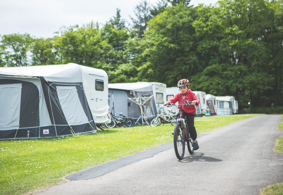 child on bike near tents kids cycling bikes at Forest Glade