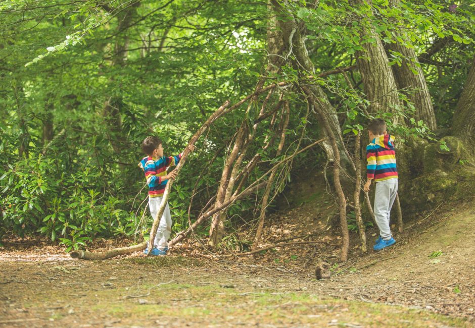 children young children building tree fort playing outside woodland walks nature trails at Forest Glade