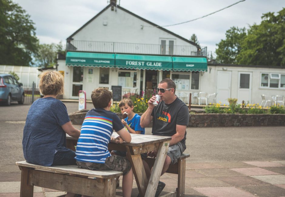 family eating snacks outside forest
